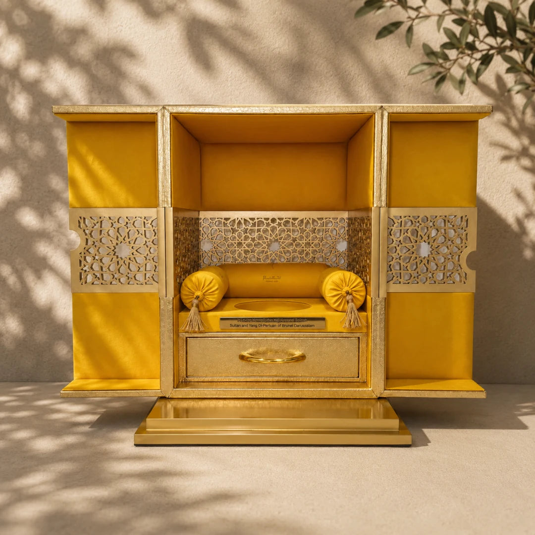 Gold-toned luxury gifting box with decorative panels and compartments